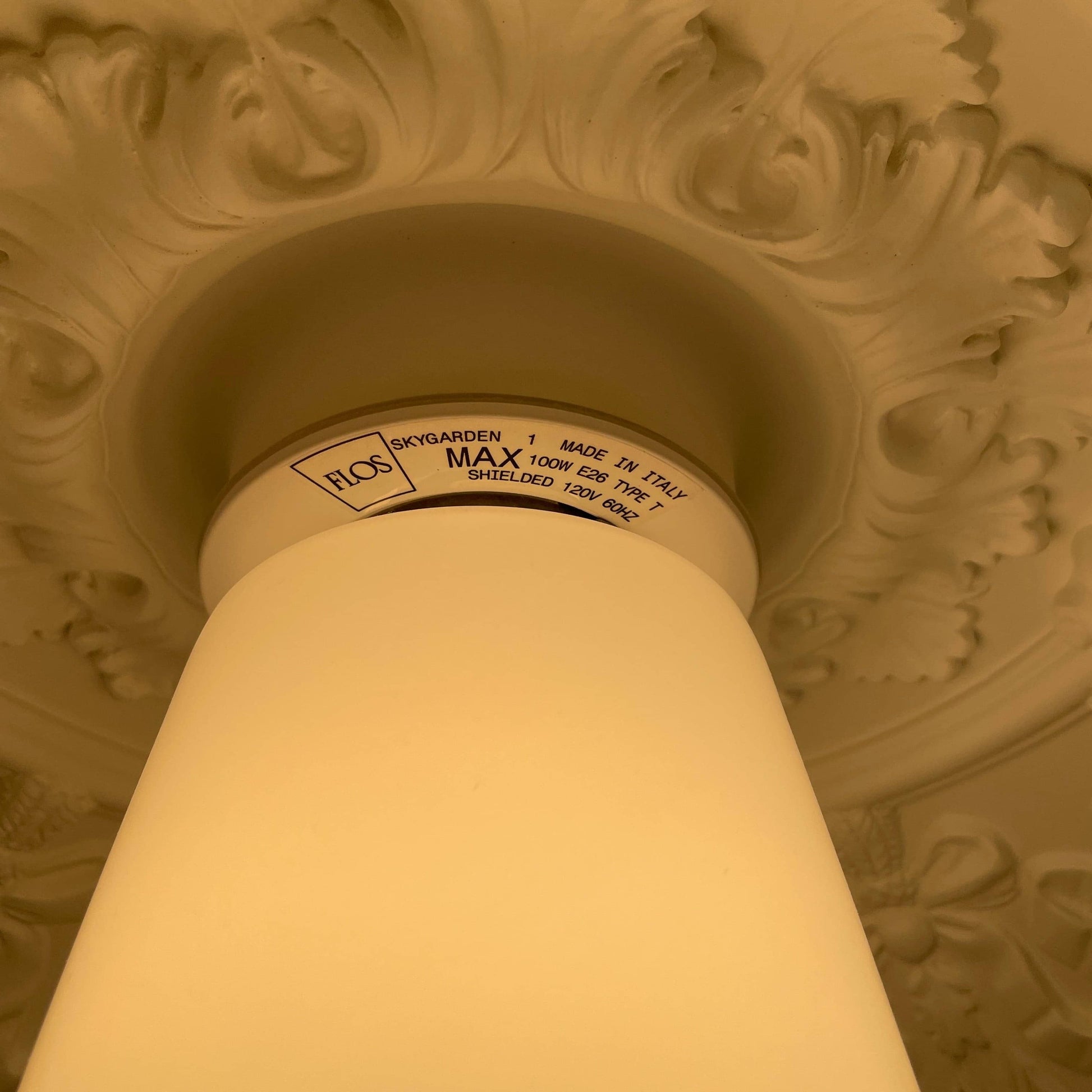 An ornate Flos Skygarden Suspension Light: Matte Rusty Brown pendant light with an interior shade.