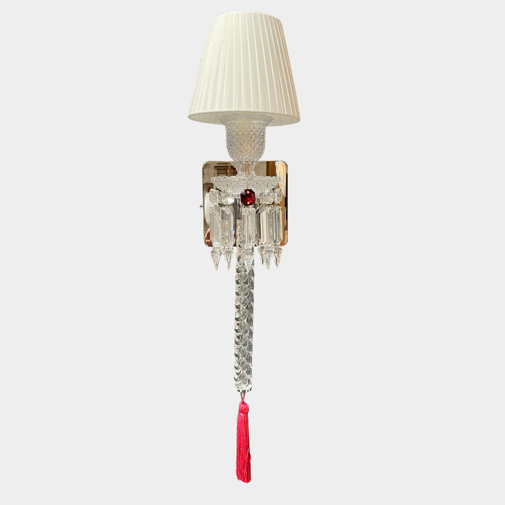 A Baccarat Torch Wall Sconce with a red tassel hanging from it.