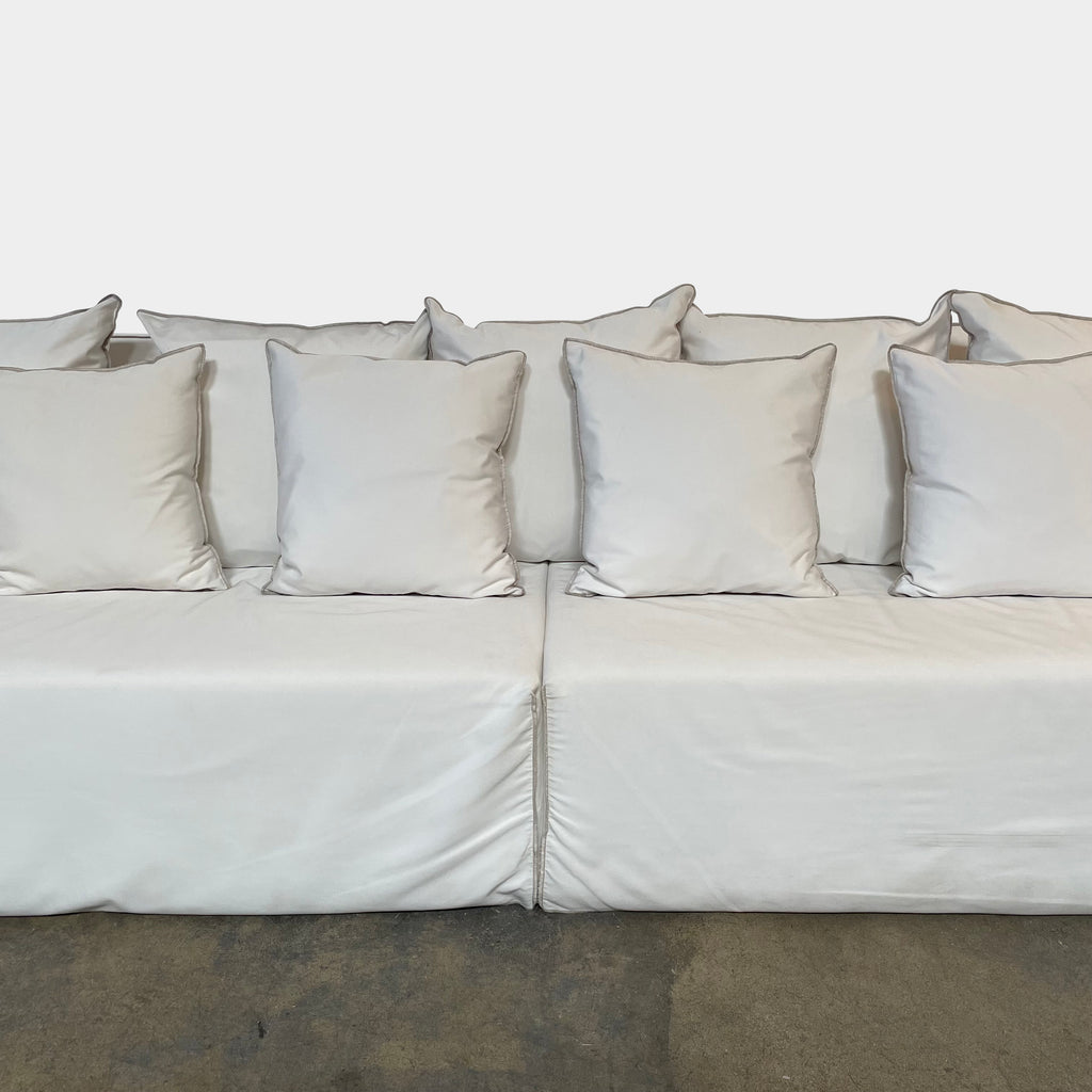 A Gervasoni Ghost Out Outdoor Sofa with several pillows on it.