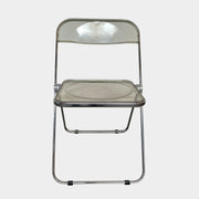 The Anonima Castelli Plia Folding Chair by Castelli, highlighted against a plain white background, echoes the iconic design of Giancarlo Piretti's Plia Folding Chairs and features the innovative "3-disc pin" mechanism.