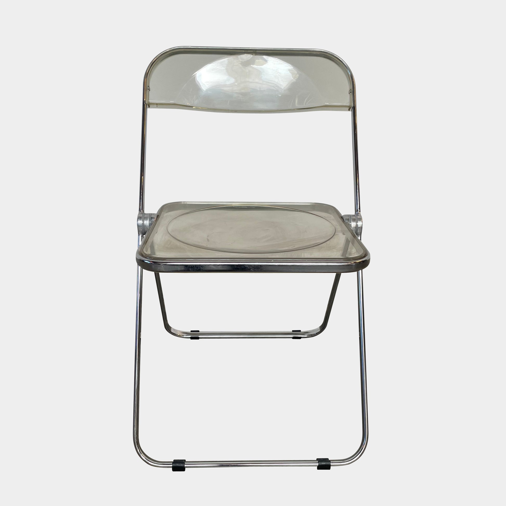 The Anonima Castelli Plia Folding Chair by Castelli, highlighted against a plain white background, echoes the iconic design of Giancarlo Piretti's Plia Folding Chairs and features the innovative "3-disc pin" mechanism.