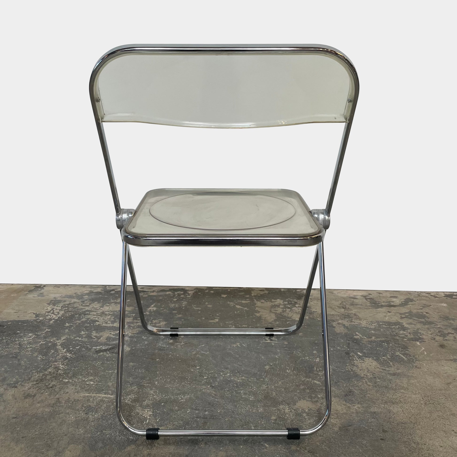 The Anonima Castelli Plia Folding Chair by Castelli, highlighted against a plain white background, echoes the iconic design of Giancarlo Piretti's Plia Folding Chairs and features the innovative "3-disc pin" mechanism.
