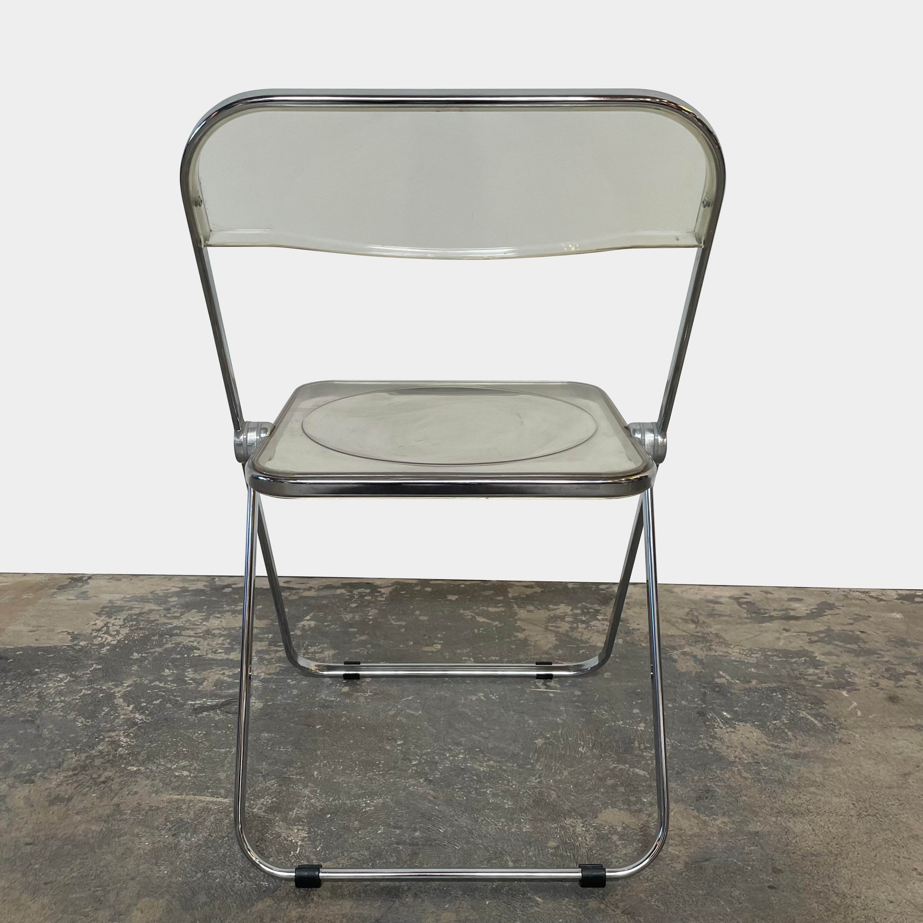 The Anonima Castelli Plia Folding Chair by Castelli, highlighted against a plain white background, echoes the iconic design of Giancarlo Piretti's Plia Folding Chairs and features the innovative "3-disc pin" mechanism.