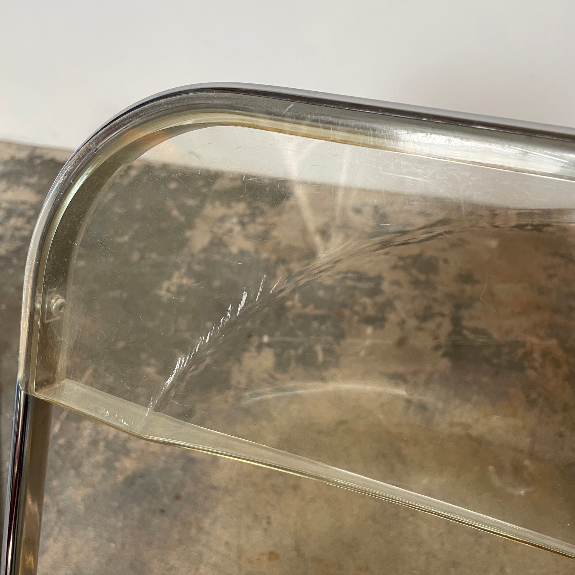 The Anonima Castelli Plia Folding Chair by Castelli, highlighted against a plain white background, echoes the iconic design of Giancarlo Piretti's Plia Folding Chairs and features the innovative "3-disc pin" mechanism.