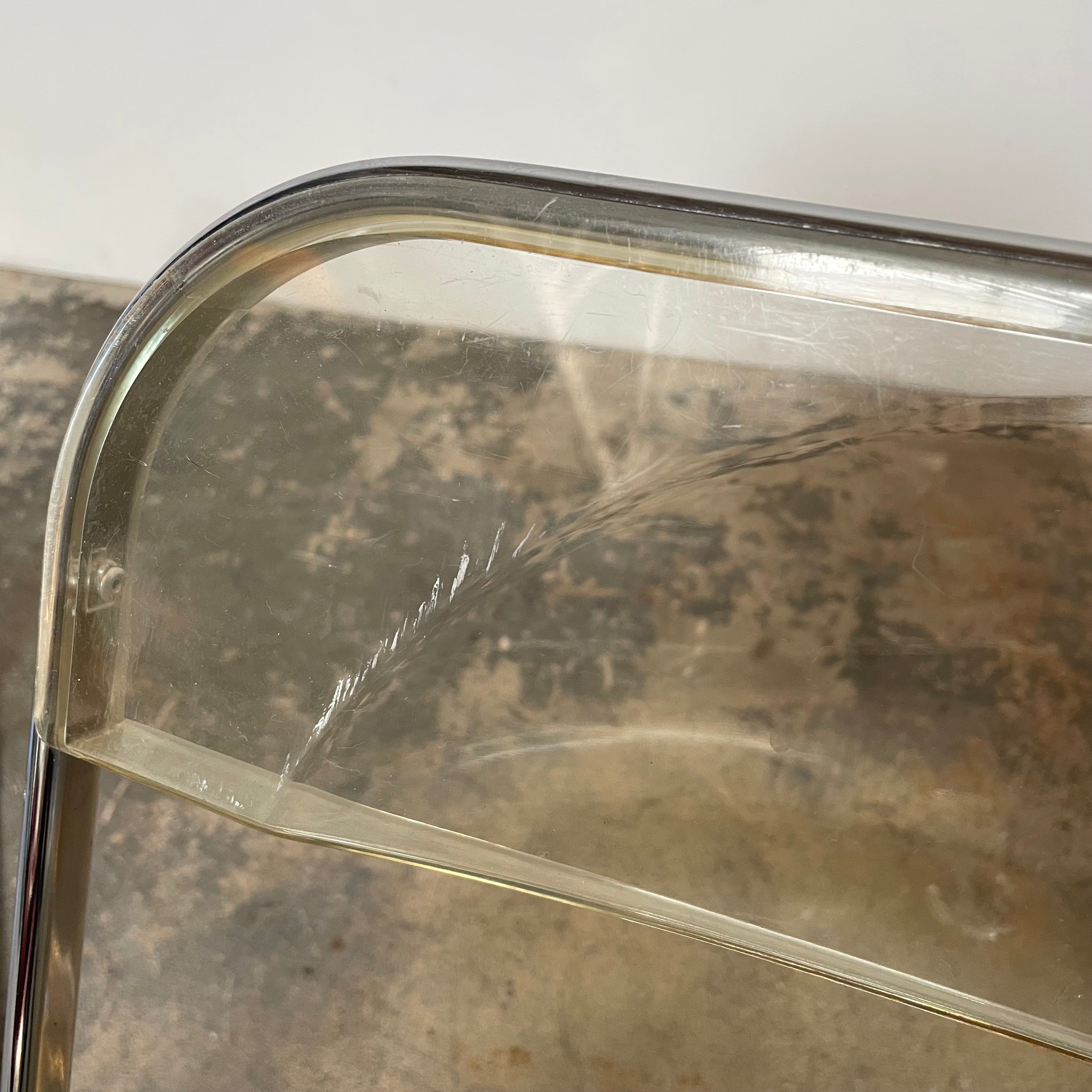 The Anonima Castelli Plia Folding Chair by Castelli, highlighted against a plain white background, echoes the iconic design of Giancarlo Piretti's Plia Folding Chairs and features the innovative "3-disc pin" mechanism.