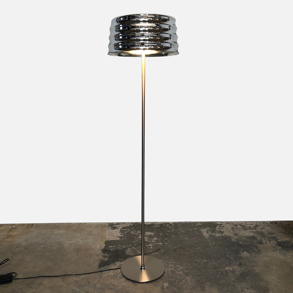 A modern Penta C'hi Floor Lamp by Umberto Asnago with a metallic base and a cylindrical, slatted shade illuminated from within, designed by Umberto Asnago, standing against a white background.