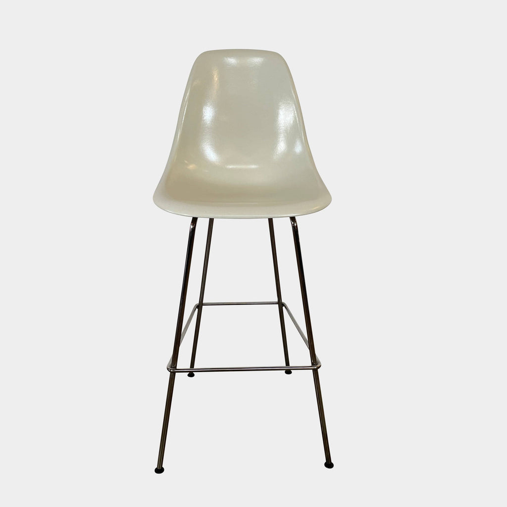 Two Herman Miller Eames Bar Height Stools with beige seats and black metal legs on a white background.
