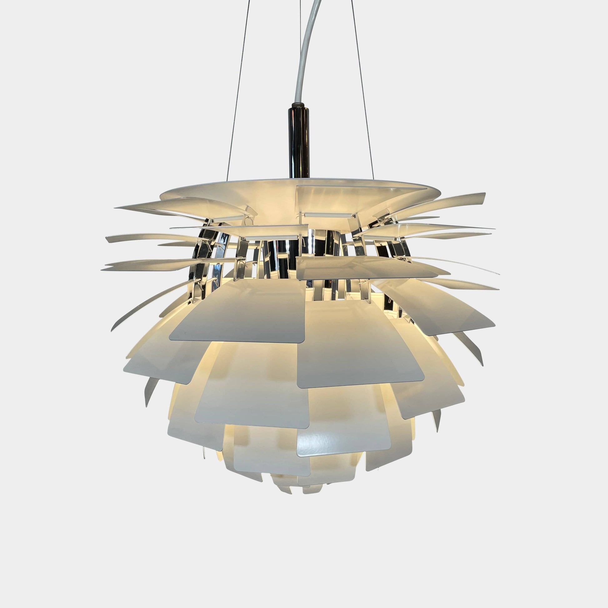 A Louis Poulsen PH Artichoke Suspension light with a white shade, providing glare-free light.