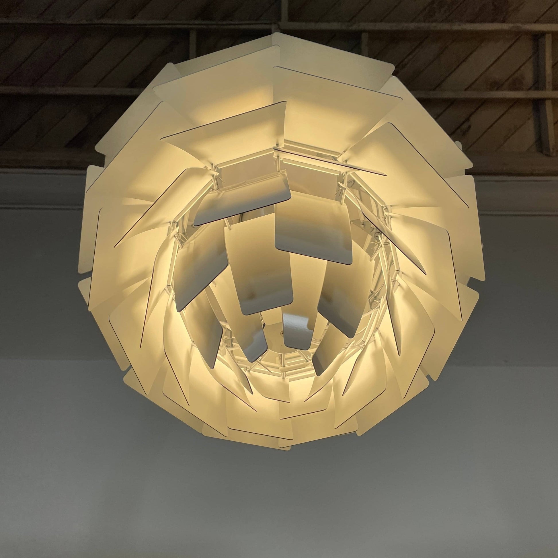 A Louis Poulsen PH Artichoke Suspension light with a white shade, providing glare-free light.
