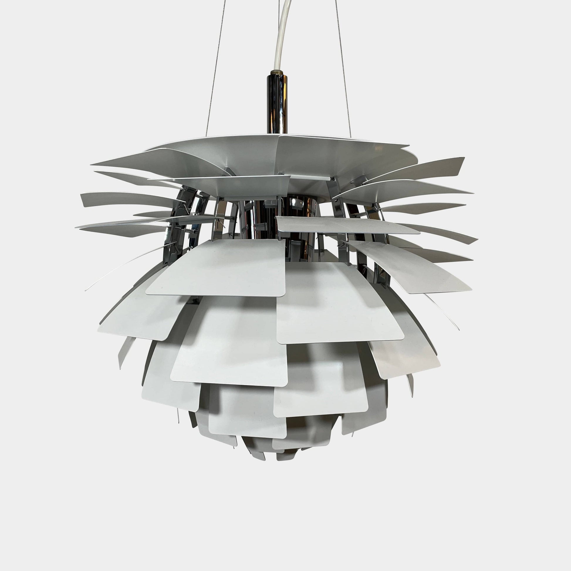A Louis Poulsen PH Artichoke Suspension light with a white shade, providing glare-free light.