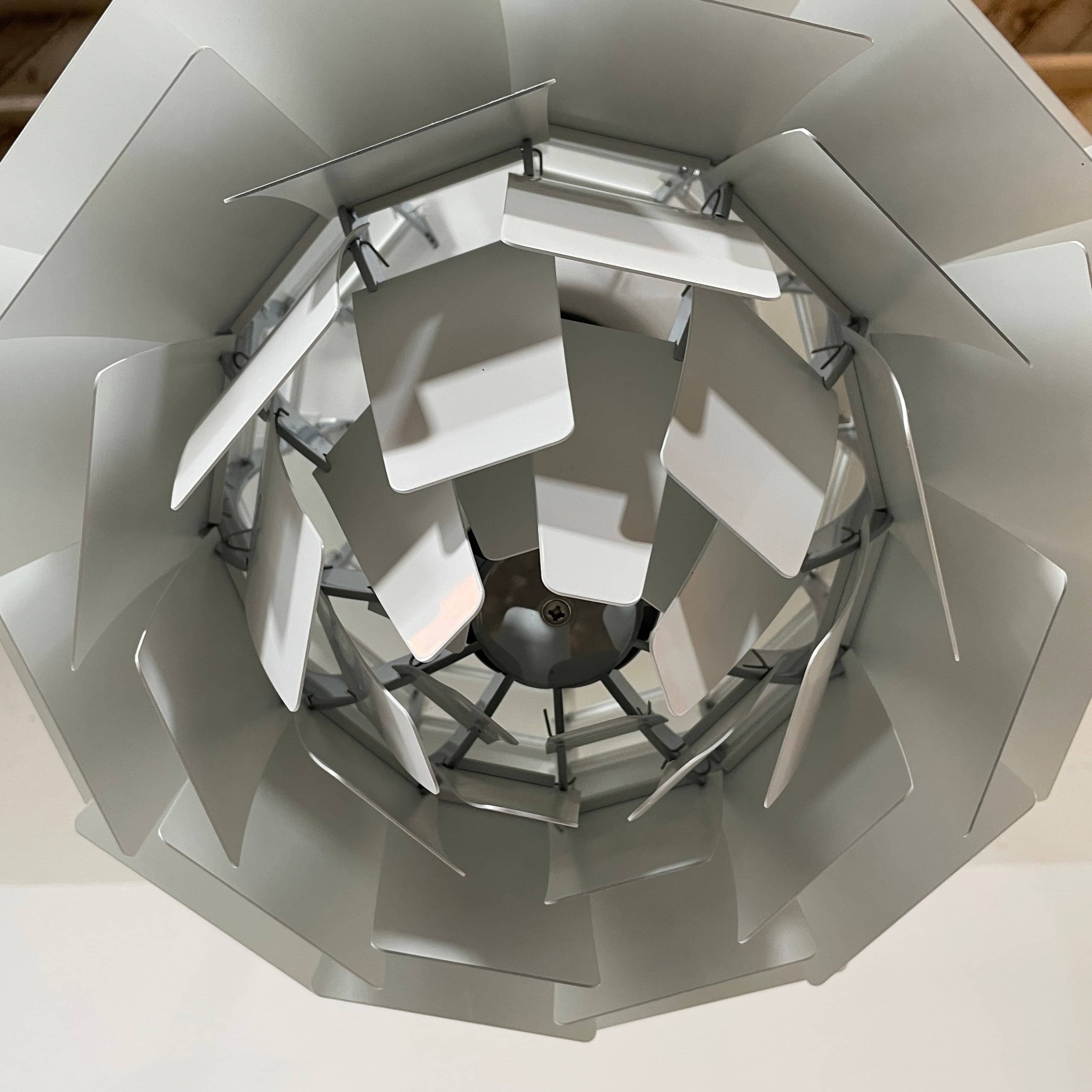 A Louis Poulsen PH Artichoke Suspension light with a white shade, providing glare-free light.