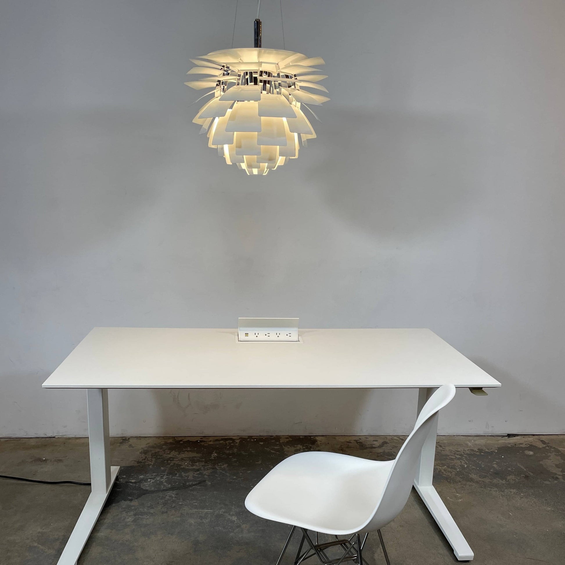 A Louis Poulsen PH Artichoke Suspension light with a white shade, providing glare-free light.