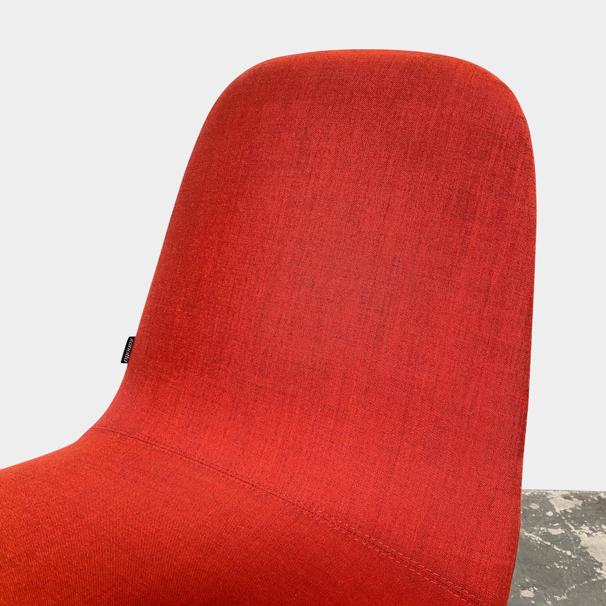 Four Zanotta Ella Dining Chairs, with their red fabric and black metal legs, are set in a row against a plain white background, showcasing the sleek design of this Italian brand.