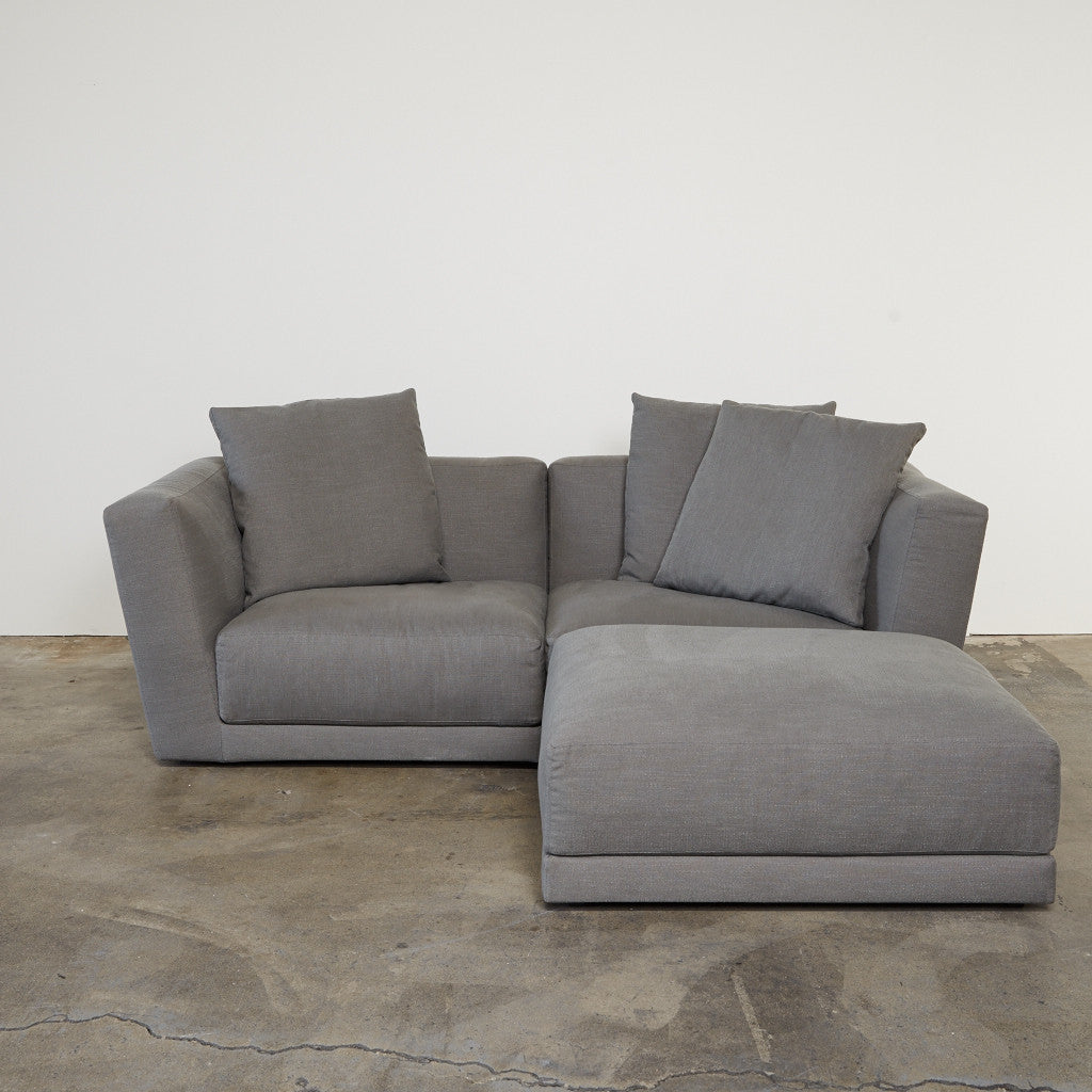 The B&B Italia Luis Sofa & Ottoman, accompanied by a matching ottoman, stands out against a crisp white background.