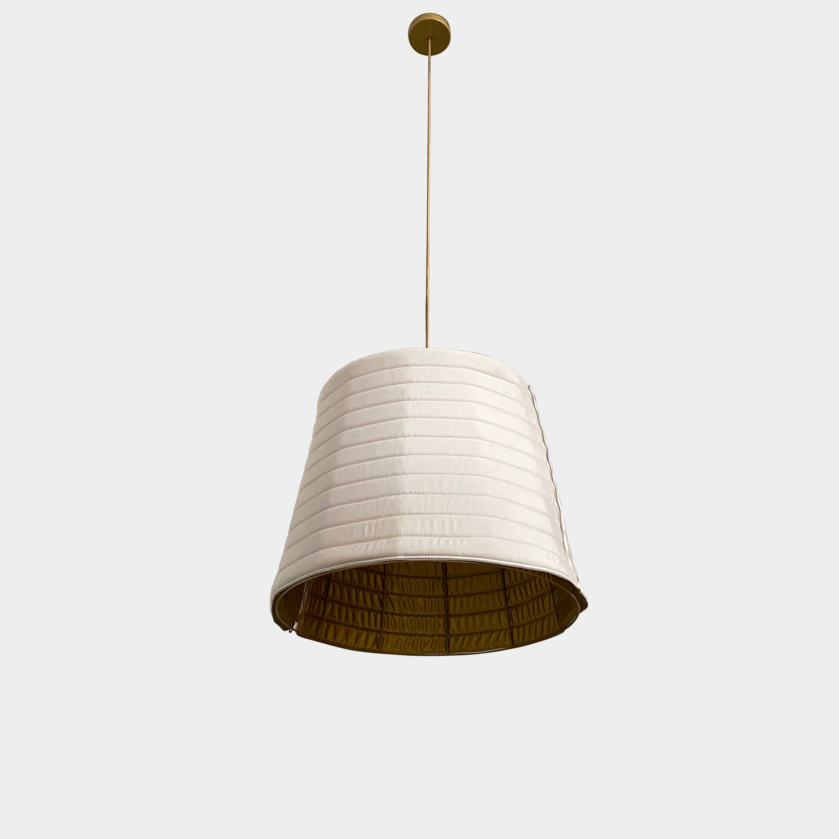 A modern suspension light featuring a white textured shade and a golden interior, suspended by a slender gold chain from Italian Vintage Ligne Roset Pharaoh Pendant.