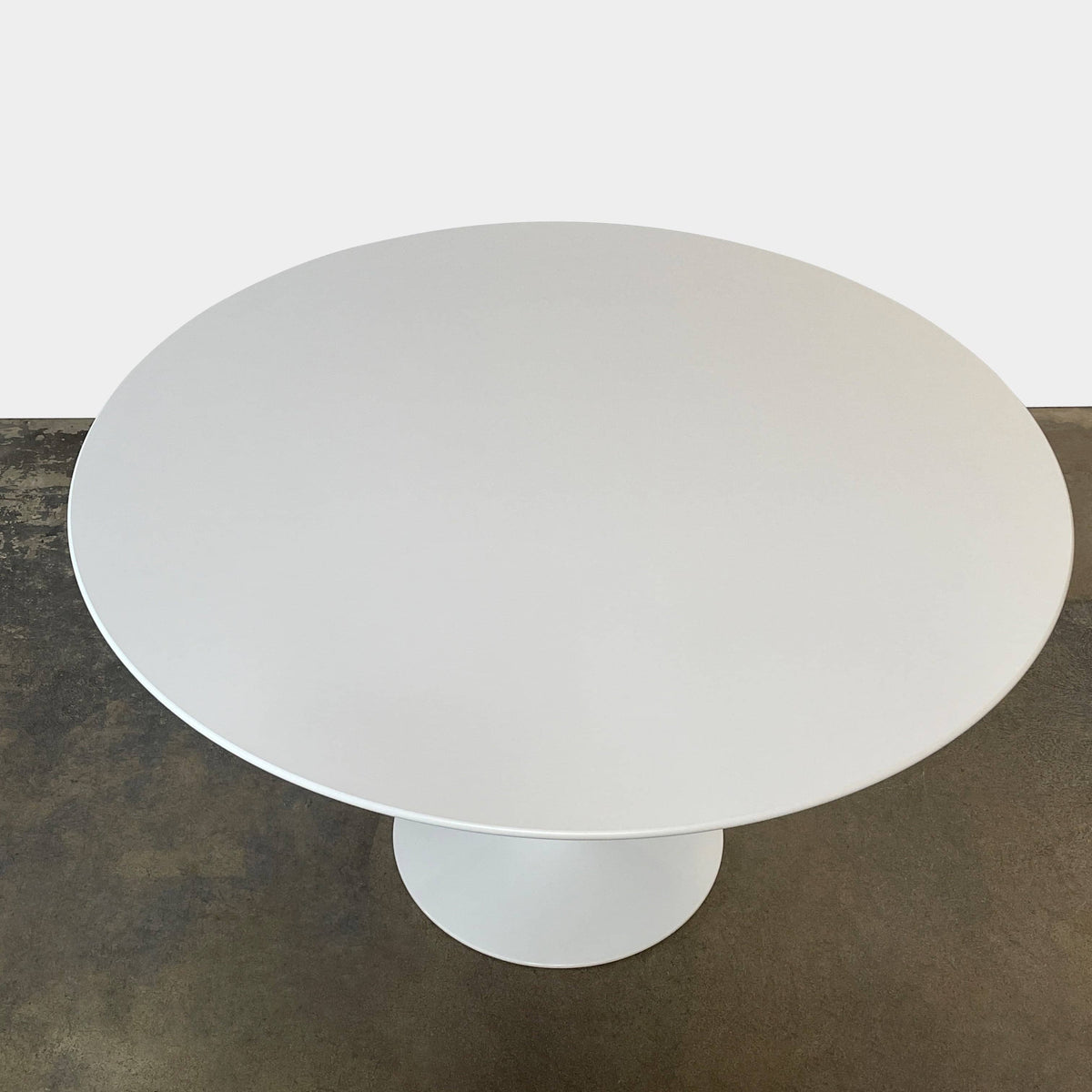 The Knoll Saarinen 47″ Dining Table, in white with a round top and single cast aluminum pedestal base, is shown against a plain white background.