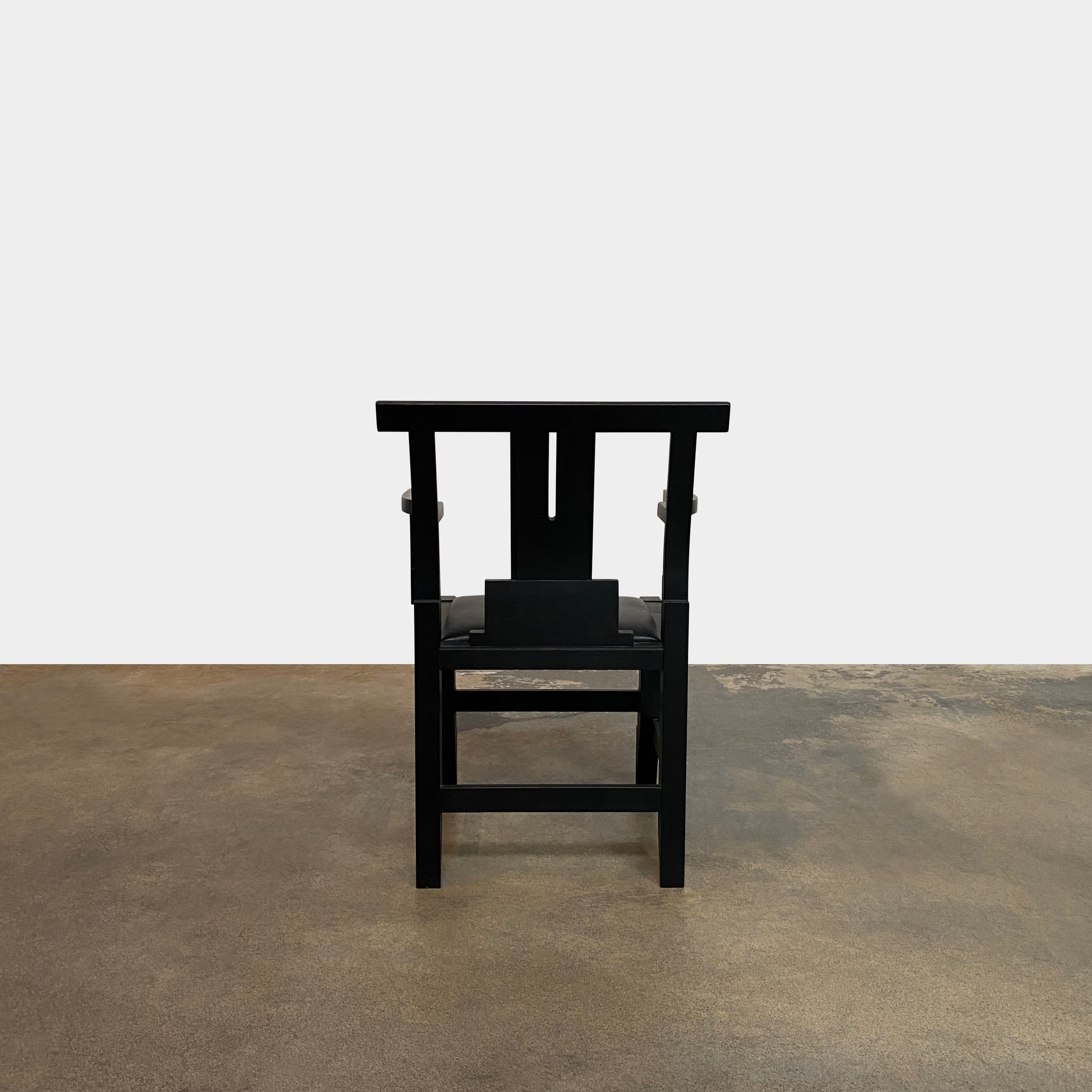 A rare vintage Solitar armchair by John Kandell, crafted in black wood, showcases an angular, geometric design that evokes the Memphis Design movement, displayed against a plain background.