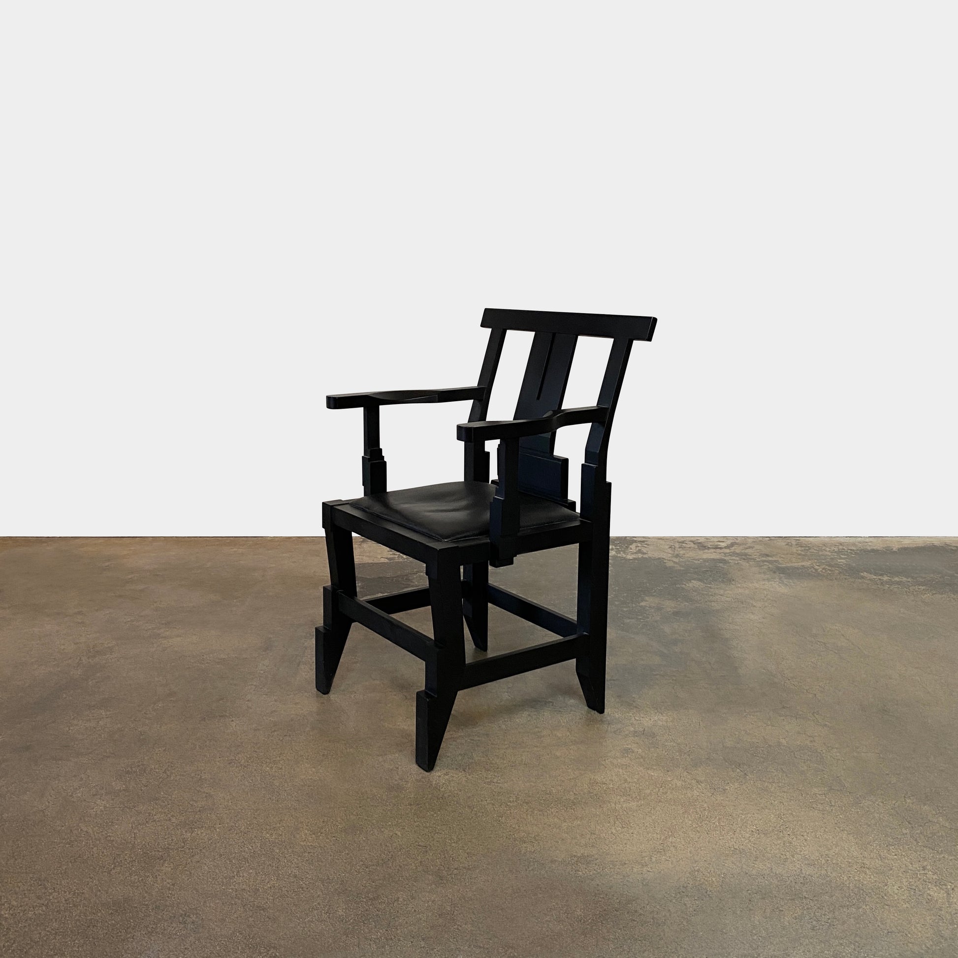 A rare vintage Solitar armchair by John Kandell, crafted in black wood, showcases an angular, geometric design that evokes the Memphis Design movement, displayed against a plain background.