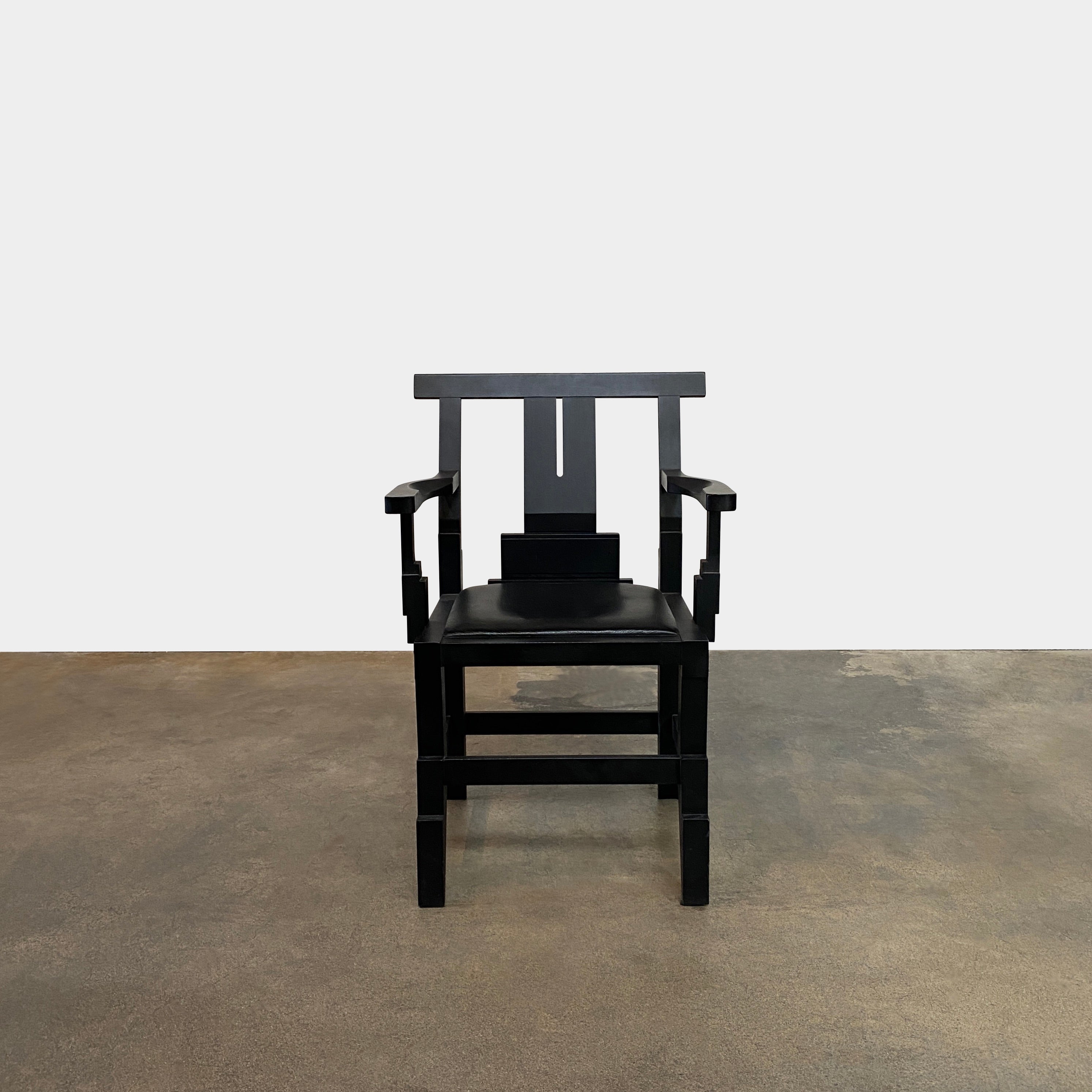 A rare vintage Solitar armchair by John Kandell, crafted in black wood, showcases an angular, geometric design that evokes the Memphis Design movement, displayed against a plain background.